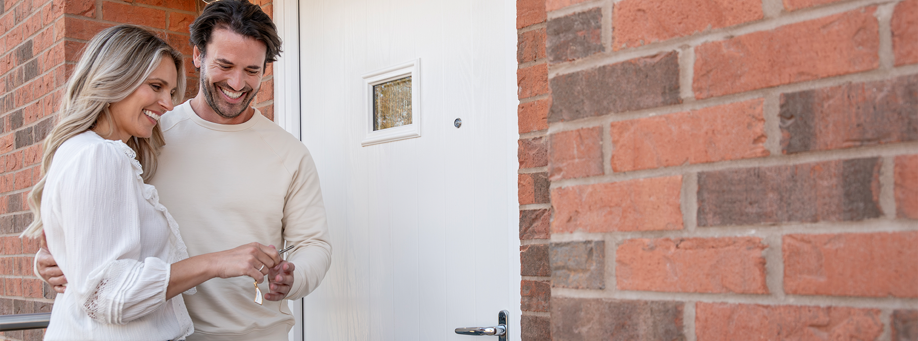 A couple opening the door to a Miller Home