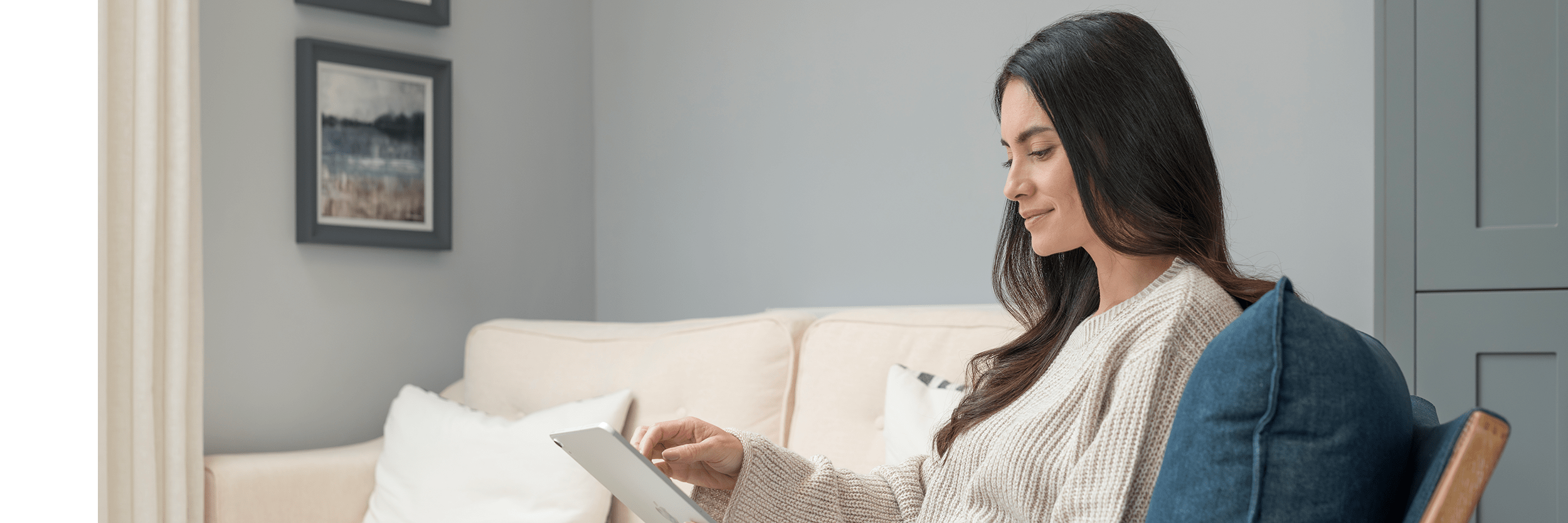 A woman in an armchair using an iPad