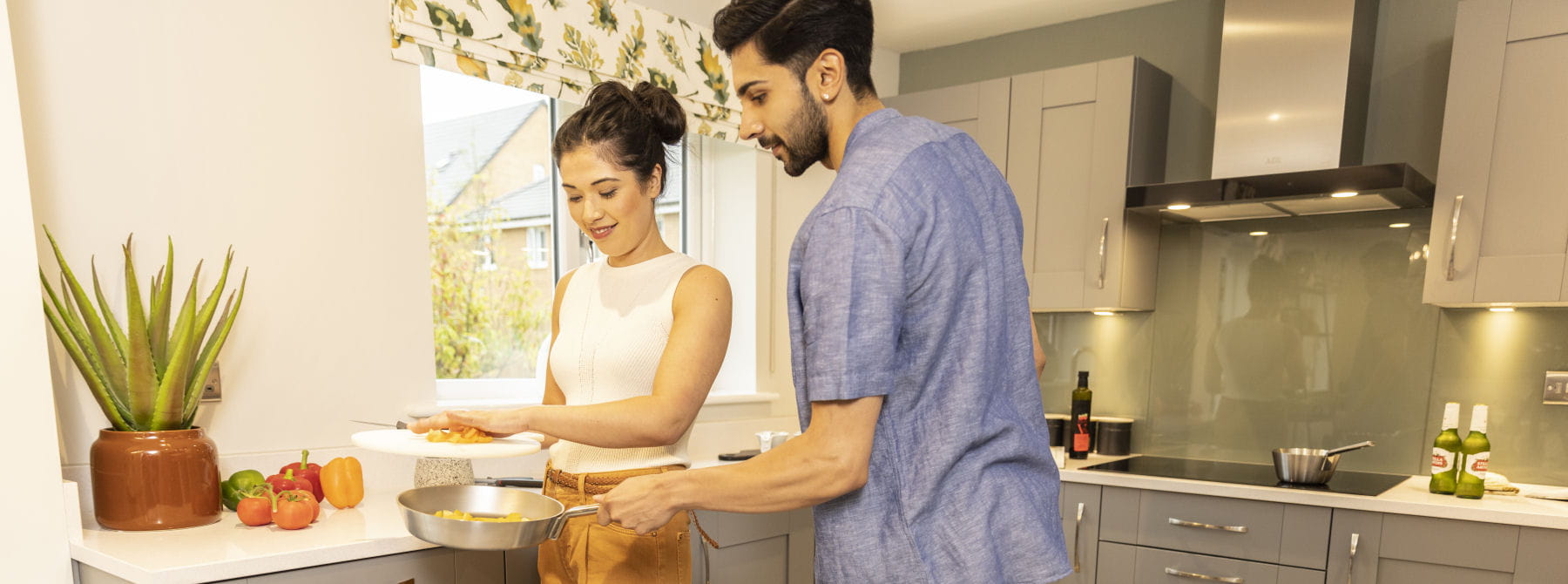 Couple cooking in their Miller Homes kitchen.
